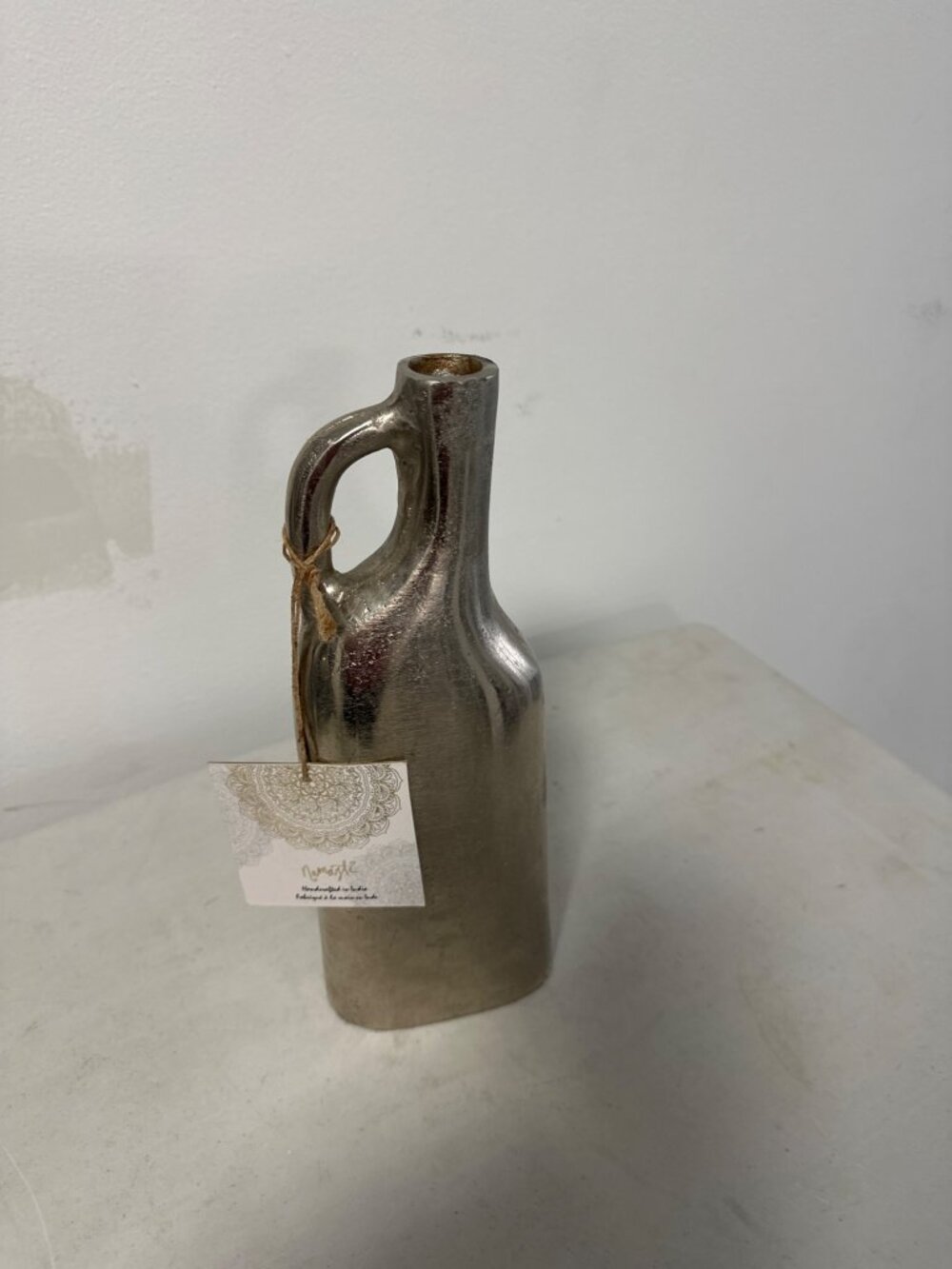 Jarrón decorativo de cerámica con acabado metálico en tono plateado envejecido .